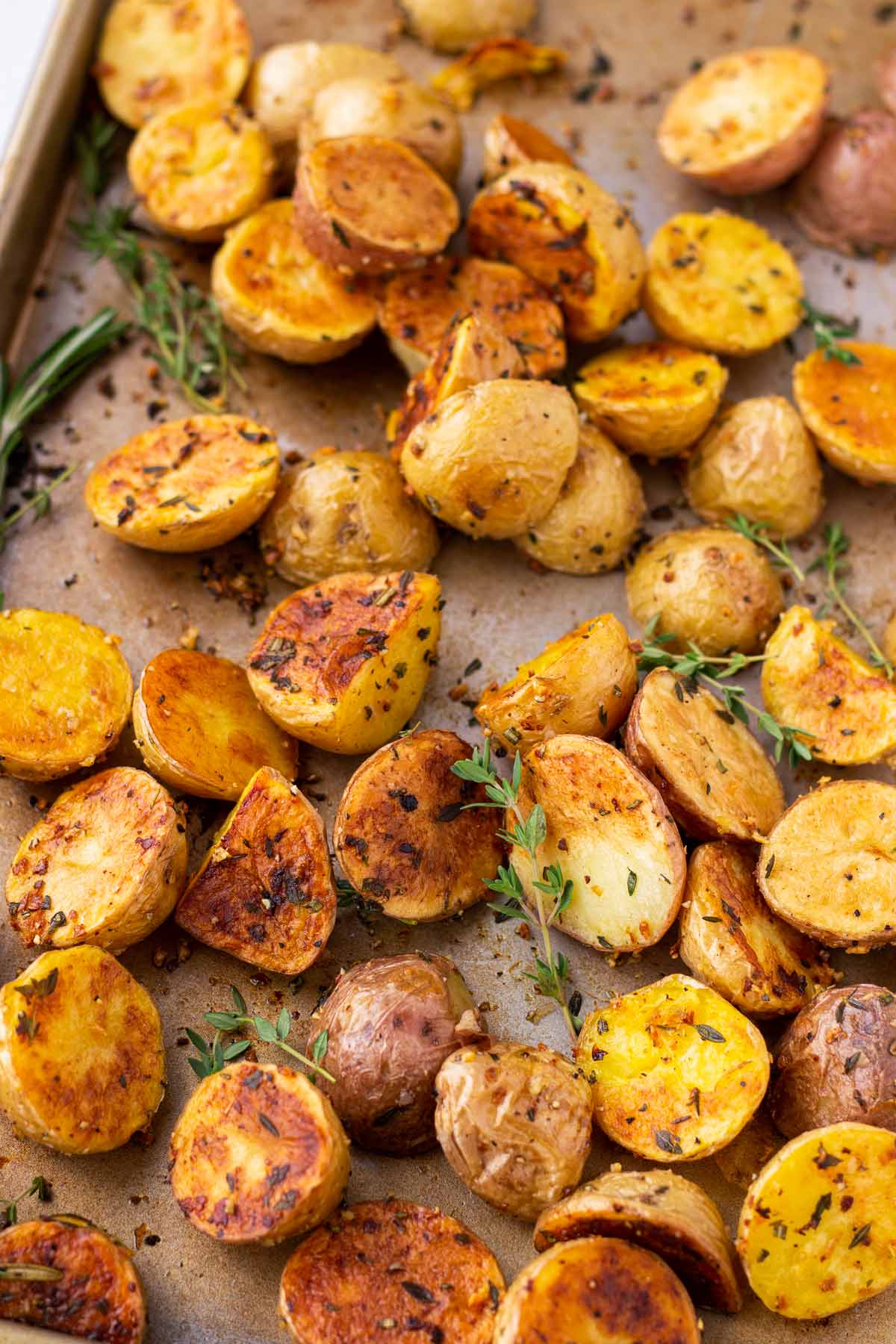 a sheet pan with herb roasted potatoes and herbs garnish