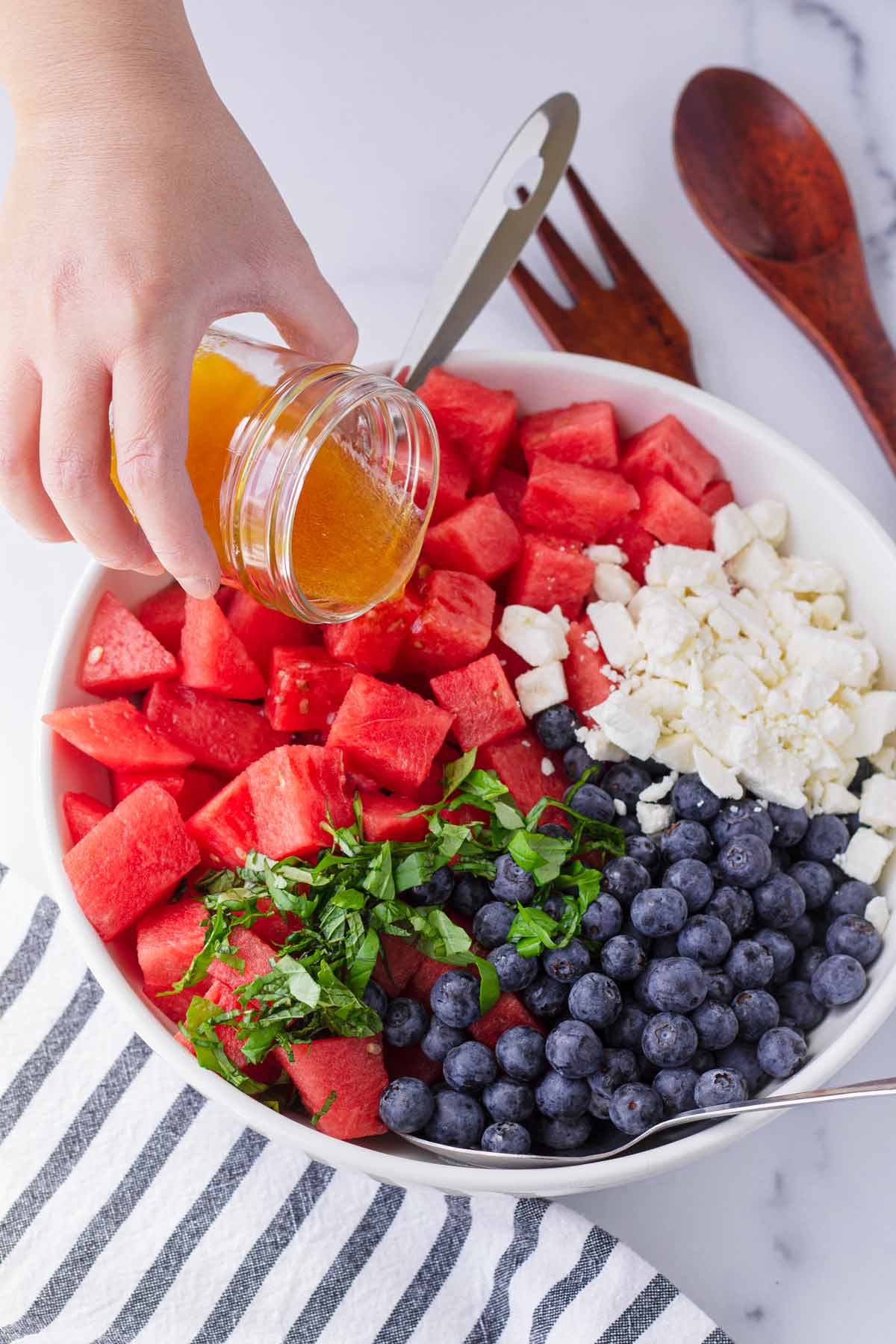 drizzling honey lime dressing into salad