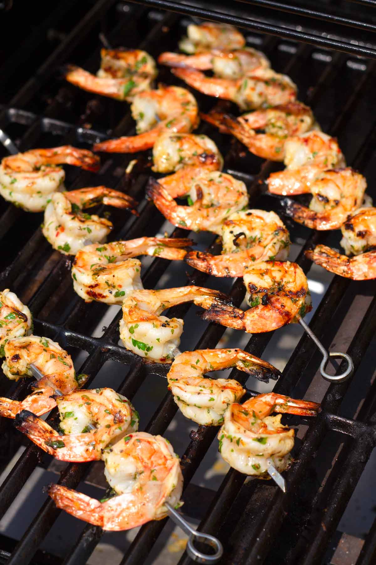 four shrimp skewers on outdoor grill