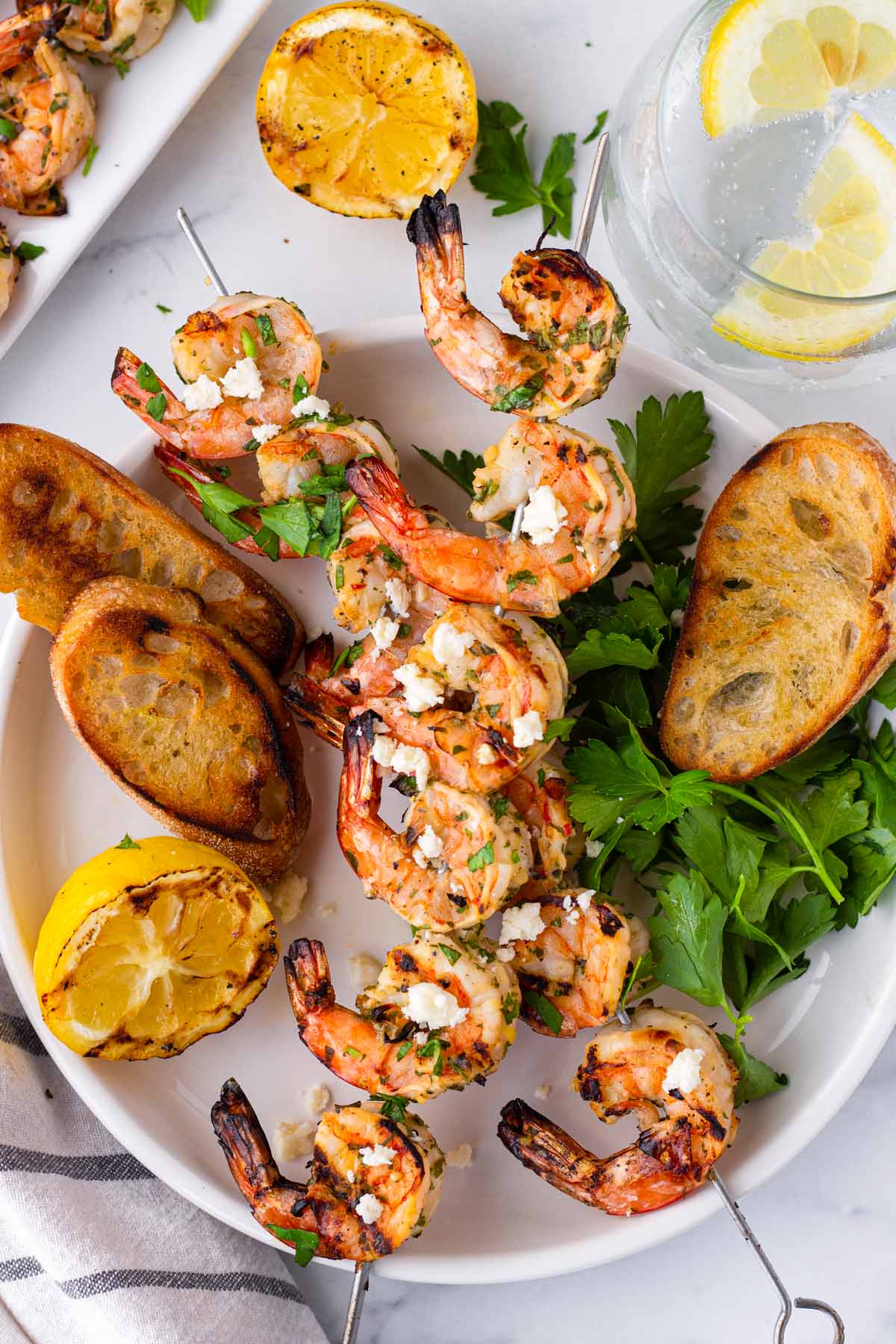 two marinated grilled shrimp skewers stacked on top of each other