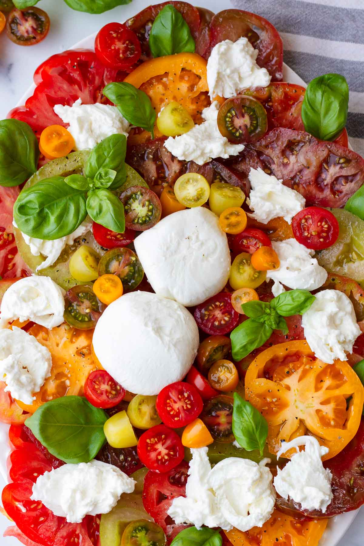 tomatoes, burrata, and basil on platter