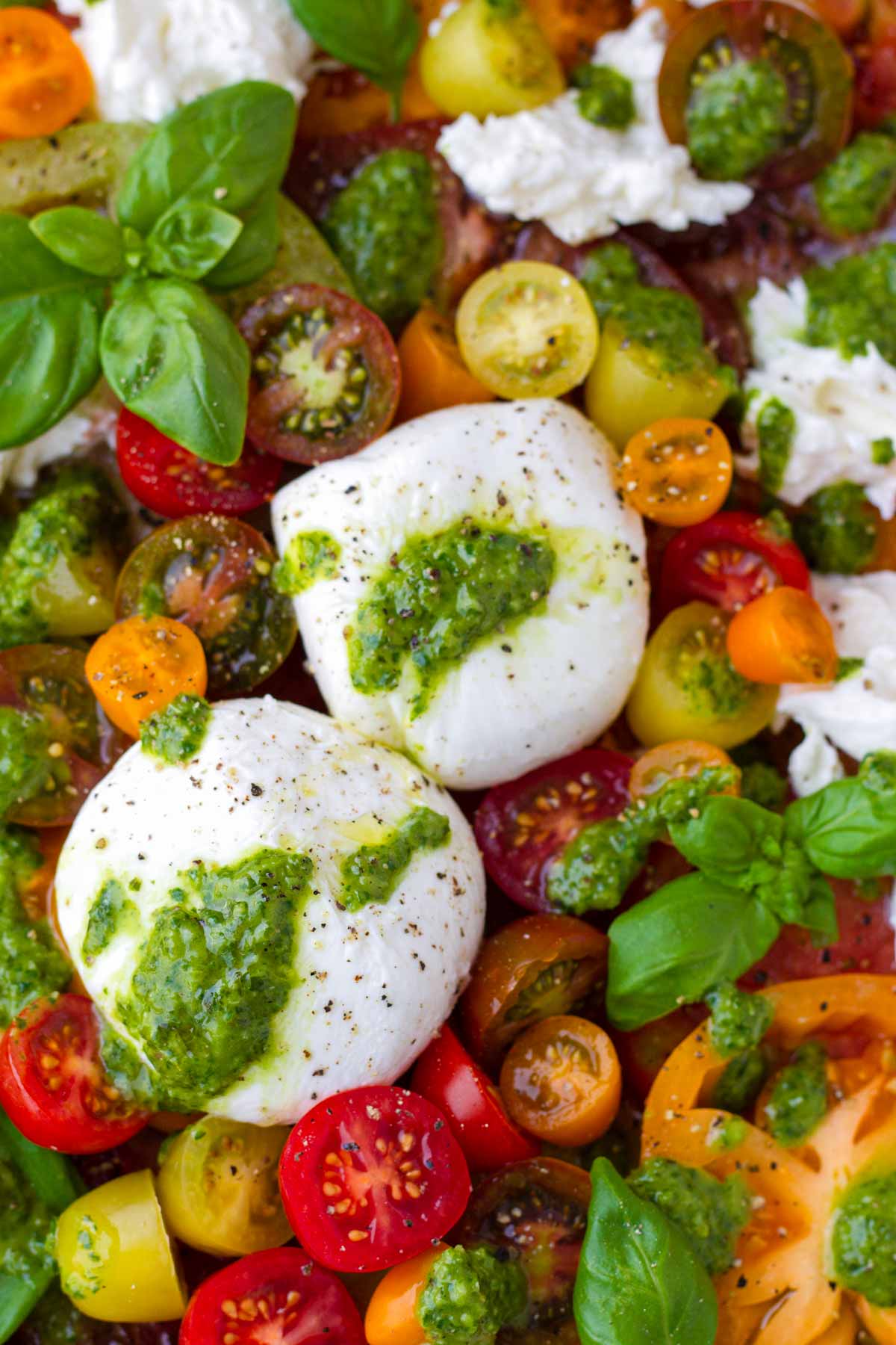 two balls of burrata on top of heirloom tomatoes