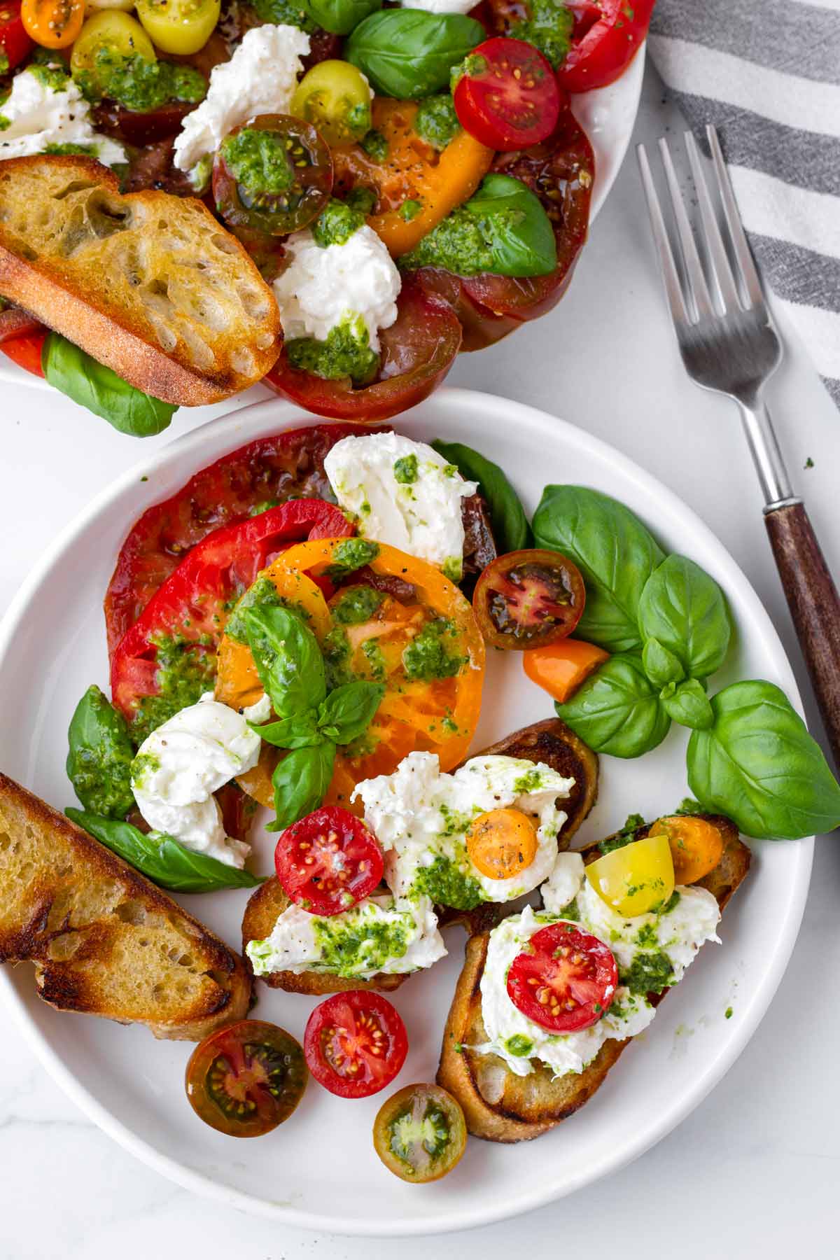 baguette toasts with burrata and tomatoes on top