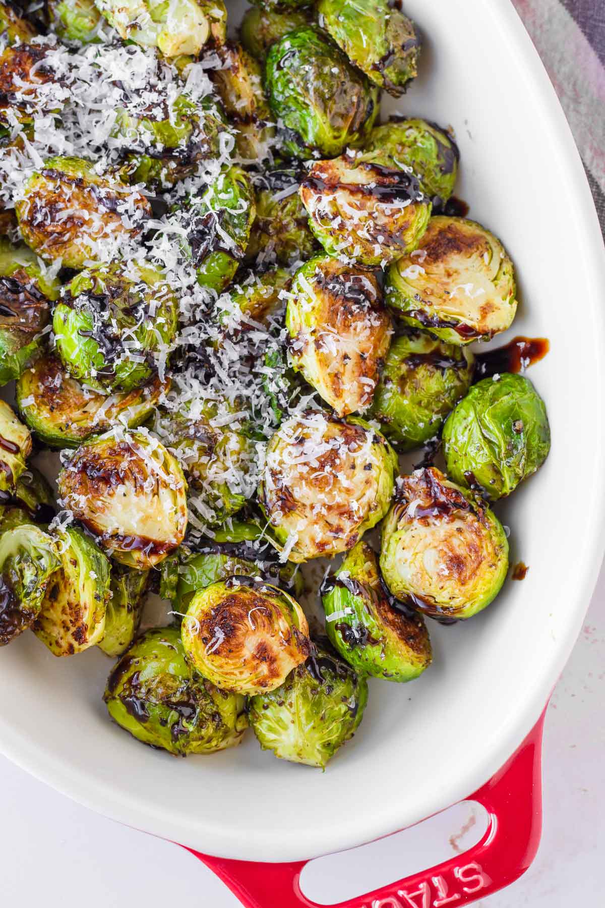 roasted brussels sprouts with glaze and parmesan in oval dish