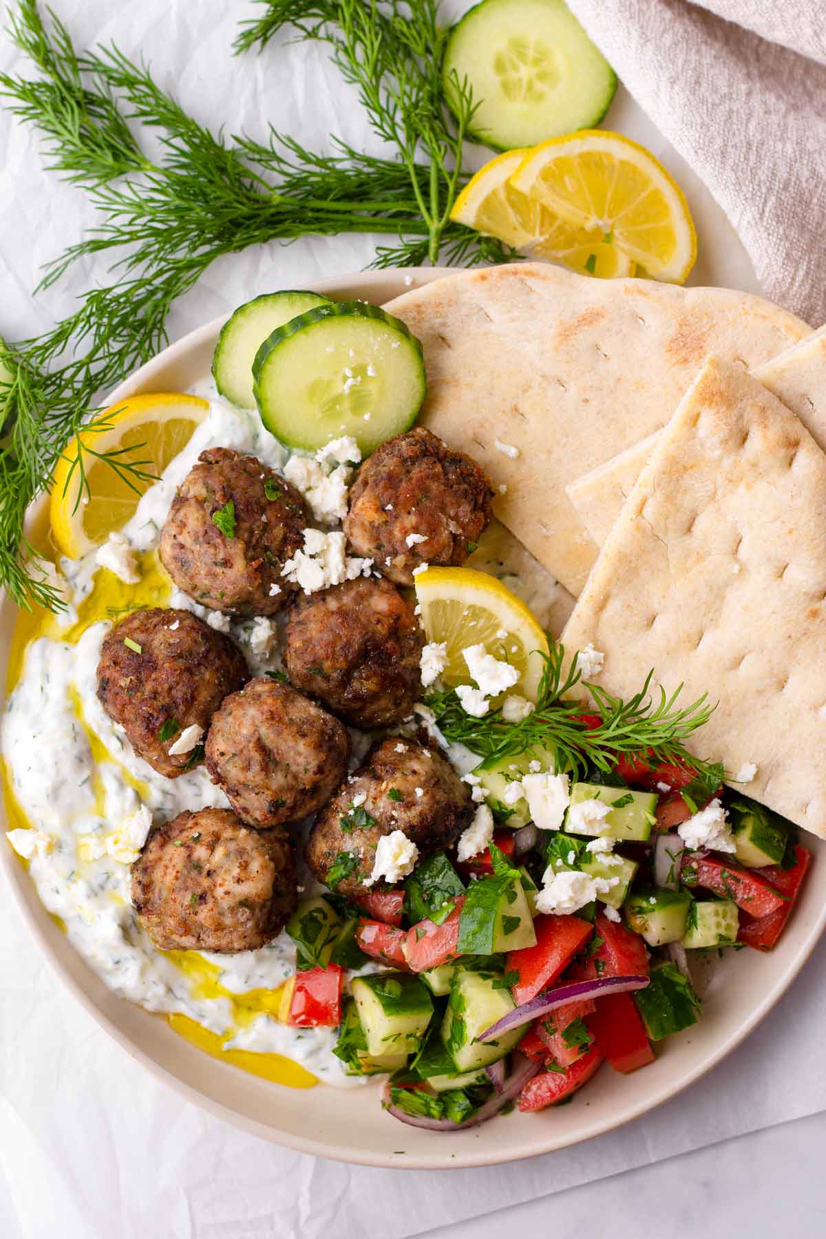 greek meatball platter with tzatziki, salad, and pita bread