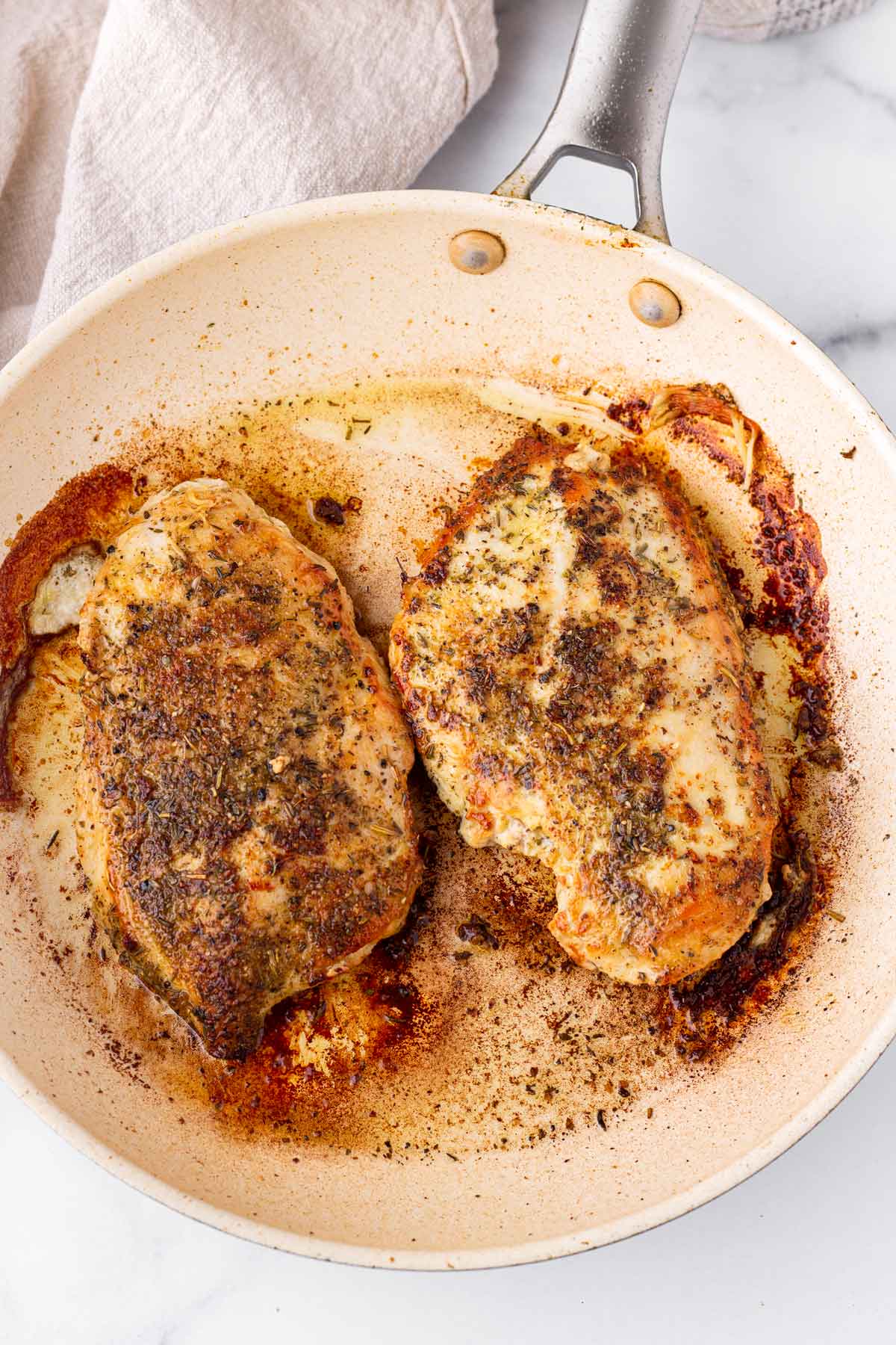 two pan seared chicken breasts in a skillet