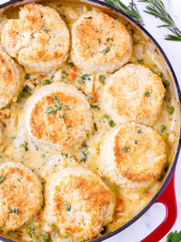 baked chicken pot pie with biscuits on top in a large skillet