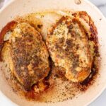 two pan seared chicken breasts on stovetop