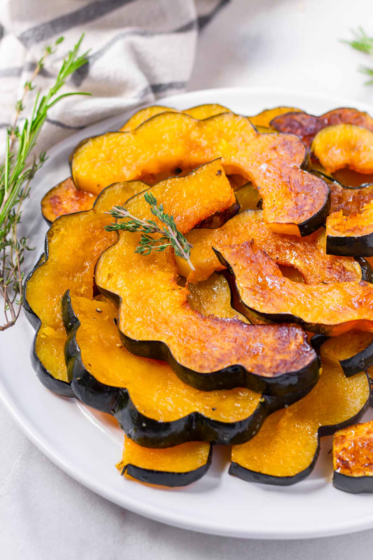 maple roasted acorn squash slices stacked on plate