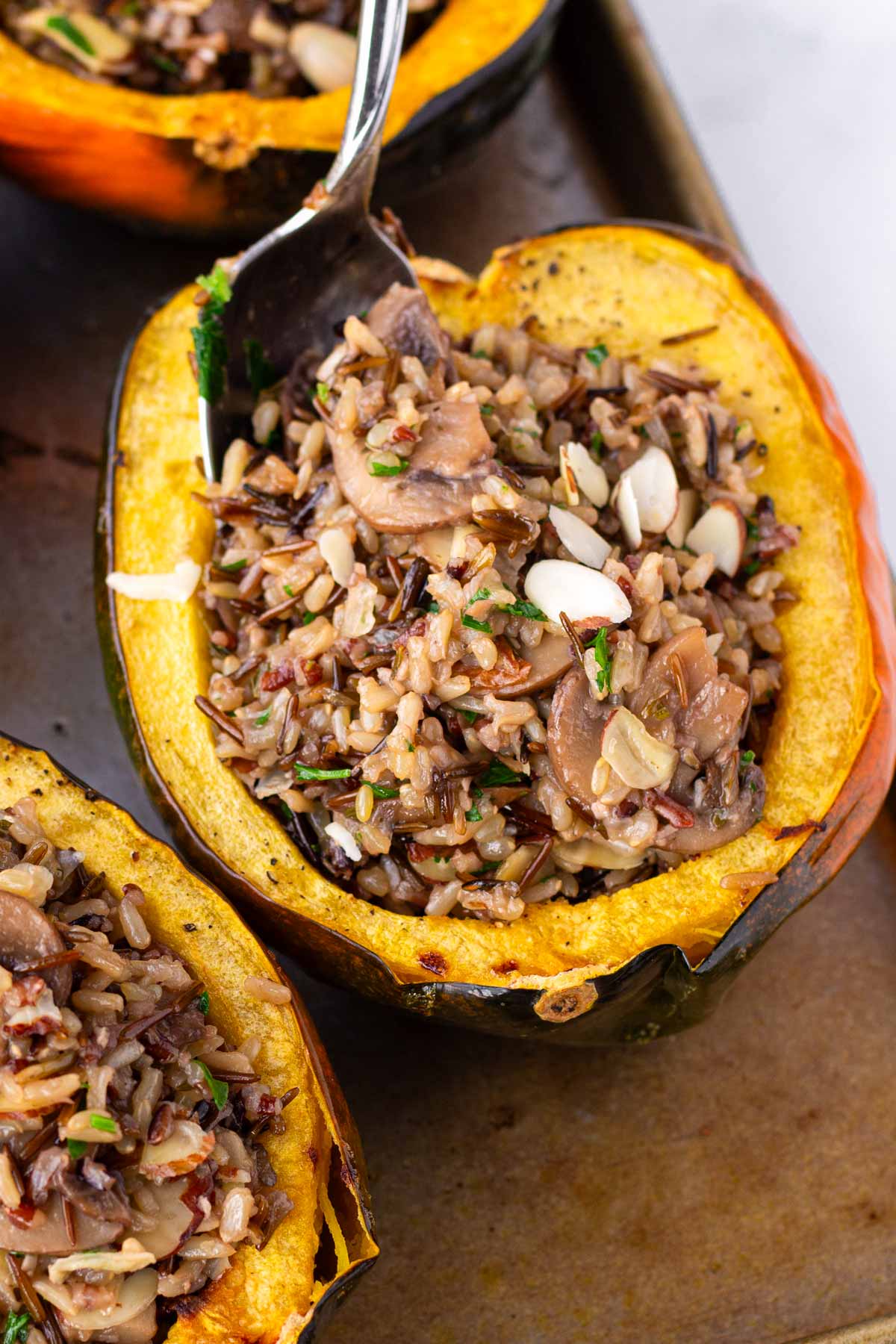 spooning filling into a roasted acorn squash