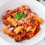 a bowl of rigatoni pasta bolognese with parmesan
