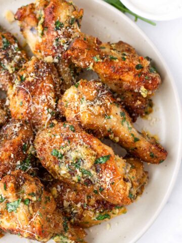 garlic parmesan wings on plate with garnish