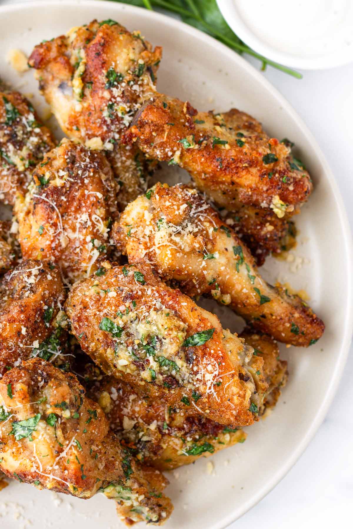 garlic parmesan wings on plate with garnish