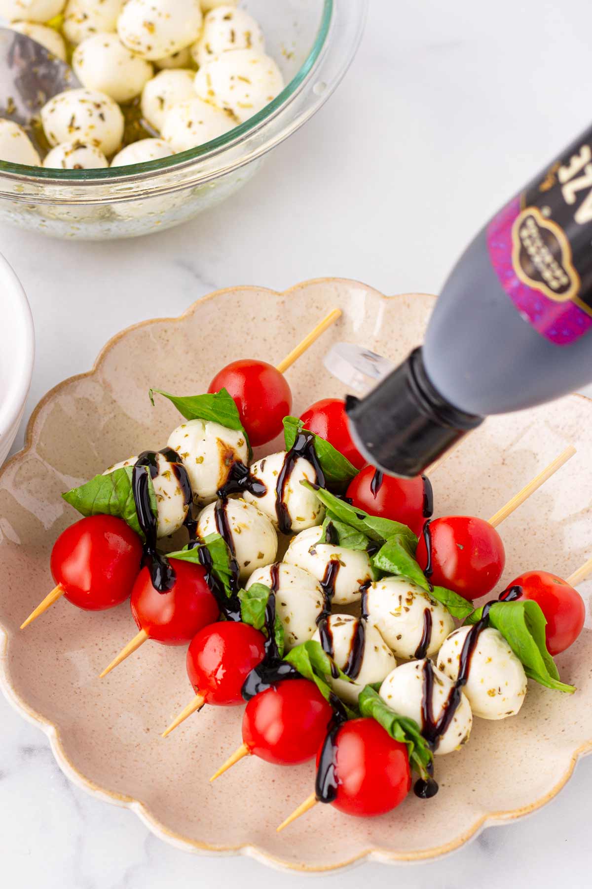 drizzling glaze over caprese skewers