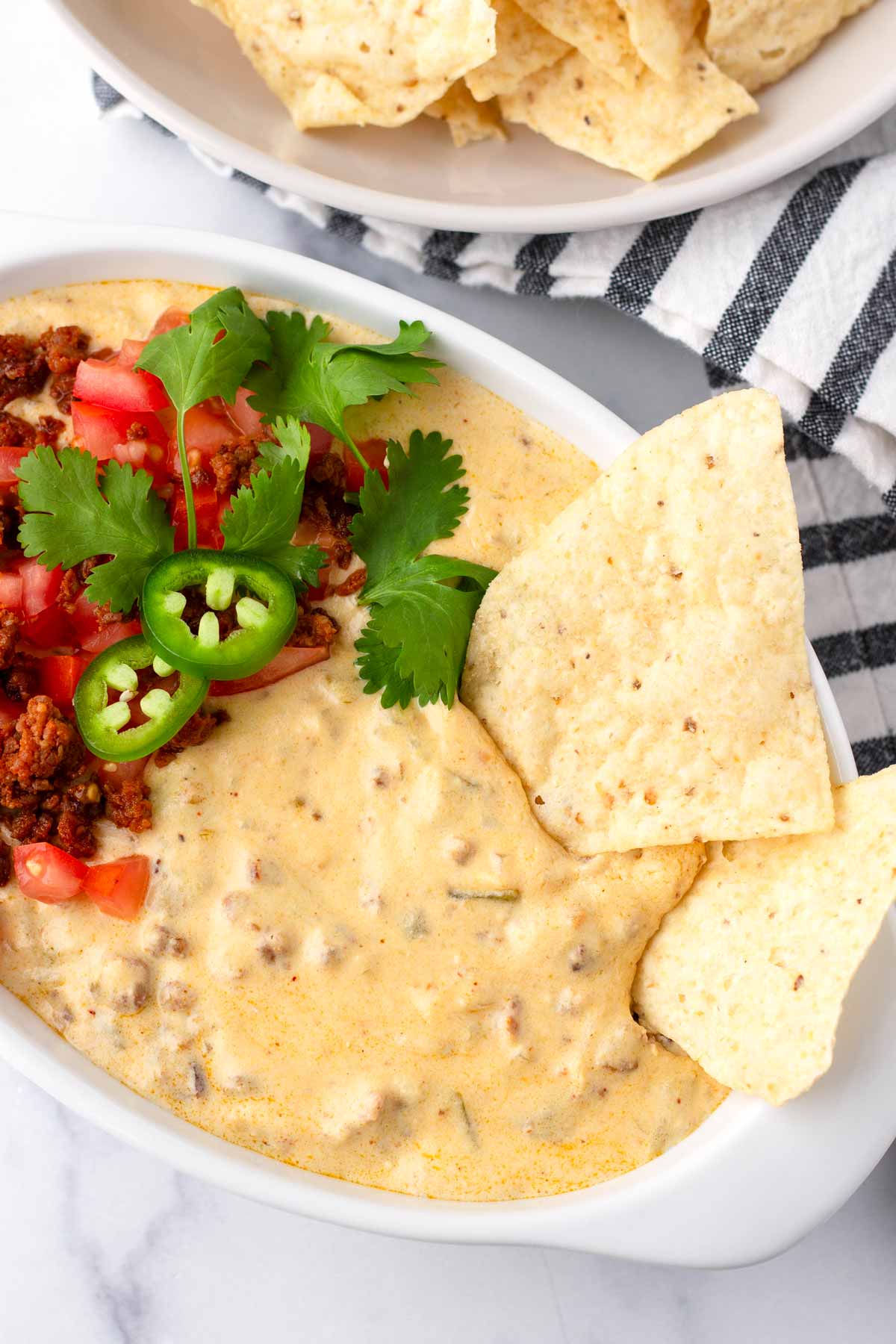 chips and chorizo queso in an oval shaped bowl