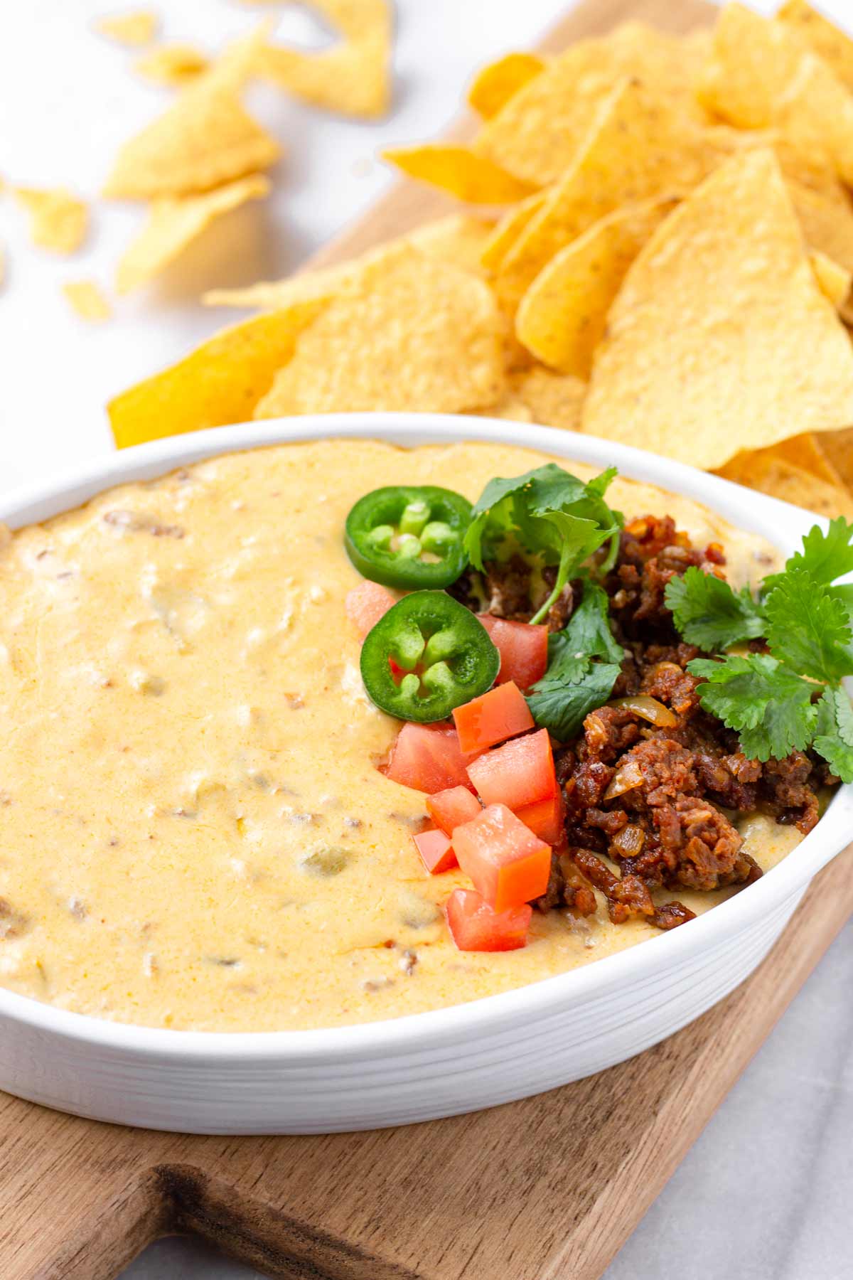 chorizo queso with chips on a wooden board
