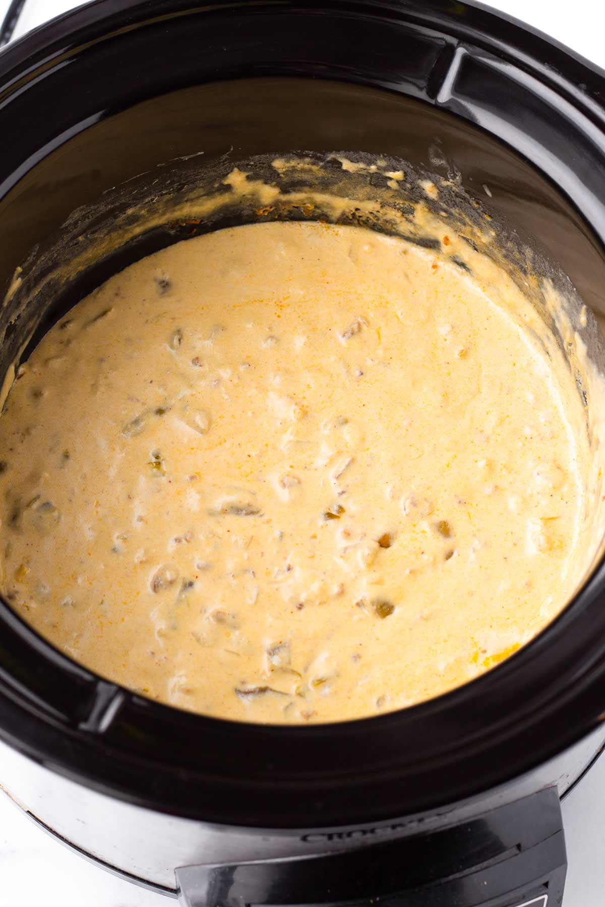 melted queso in a medium slow cooker