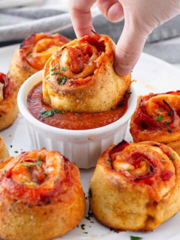 dipping a pepperoni pizza roll in marinara