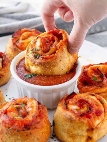 dipping a pepperoni pizza roll in marinara