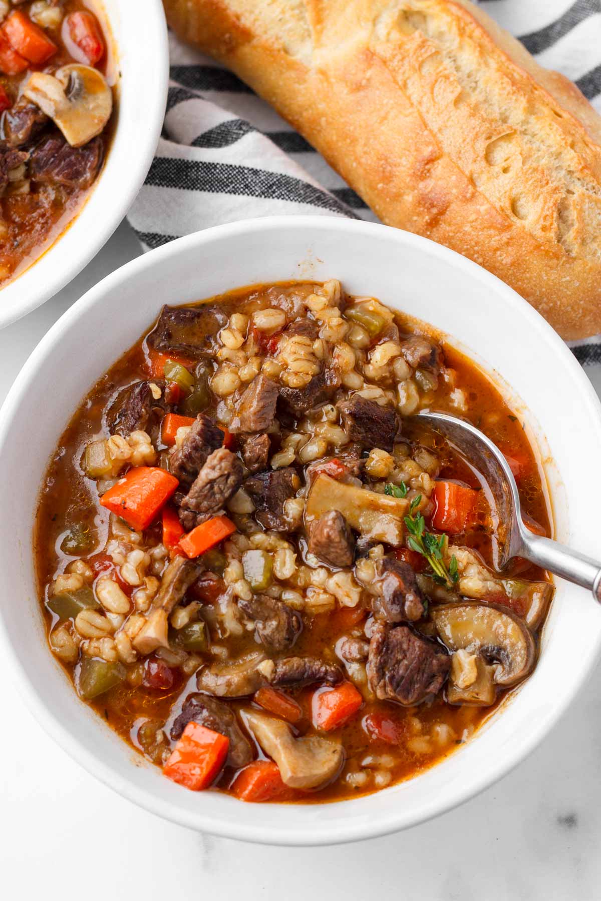 bowl of beef barley mushroom soup with bread