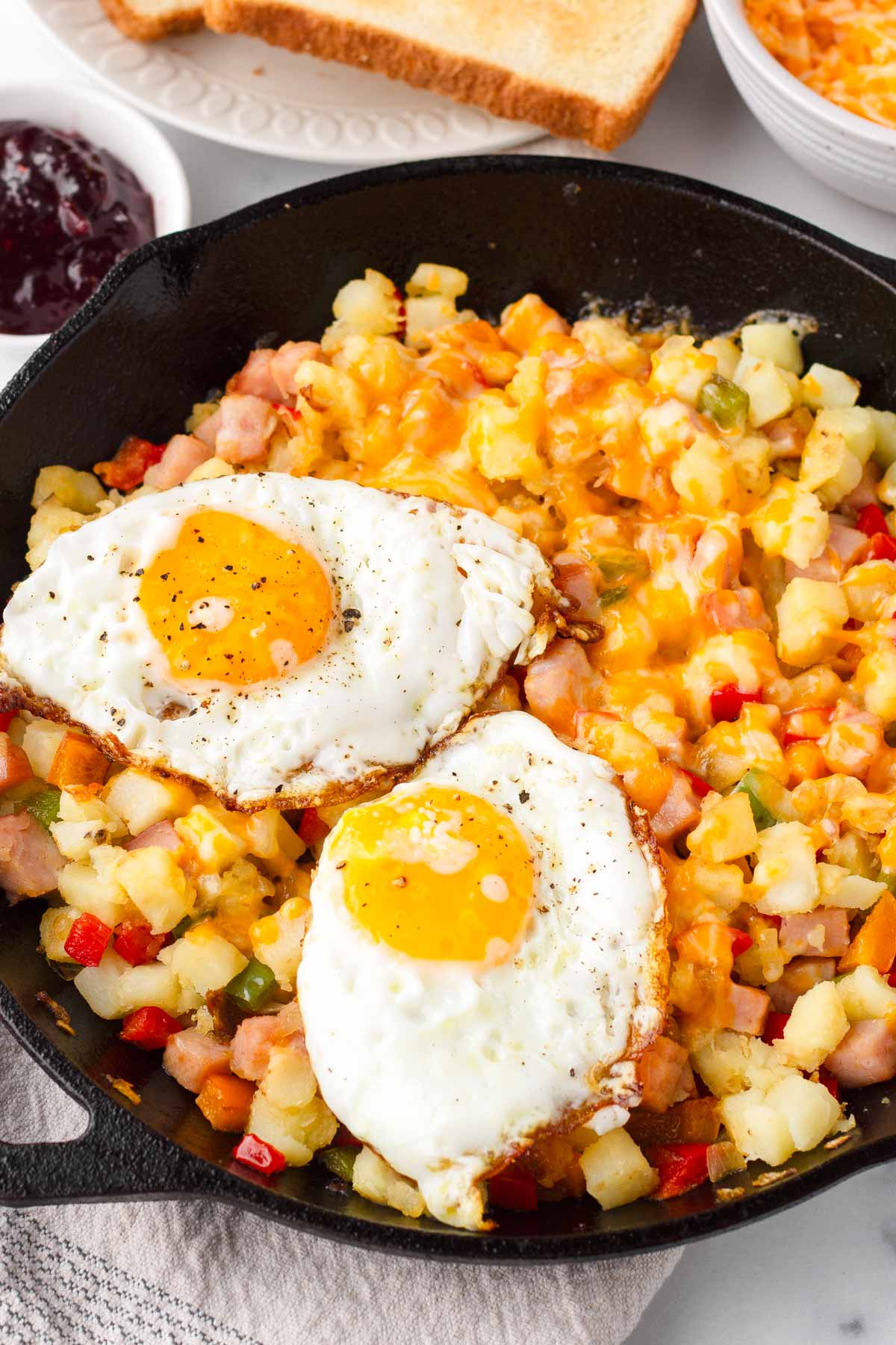 breakfast skillet with egg, potatoes, ham, and peppers