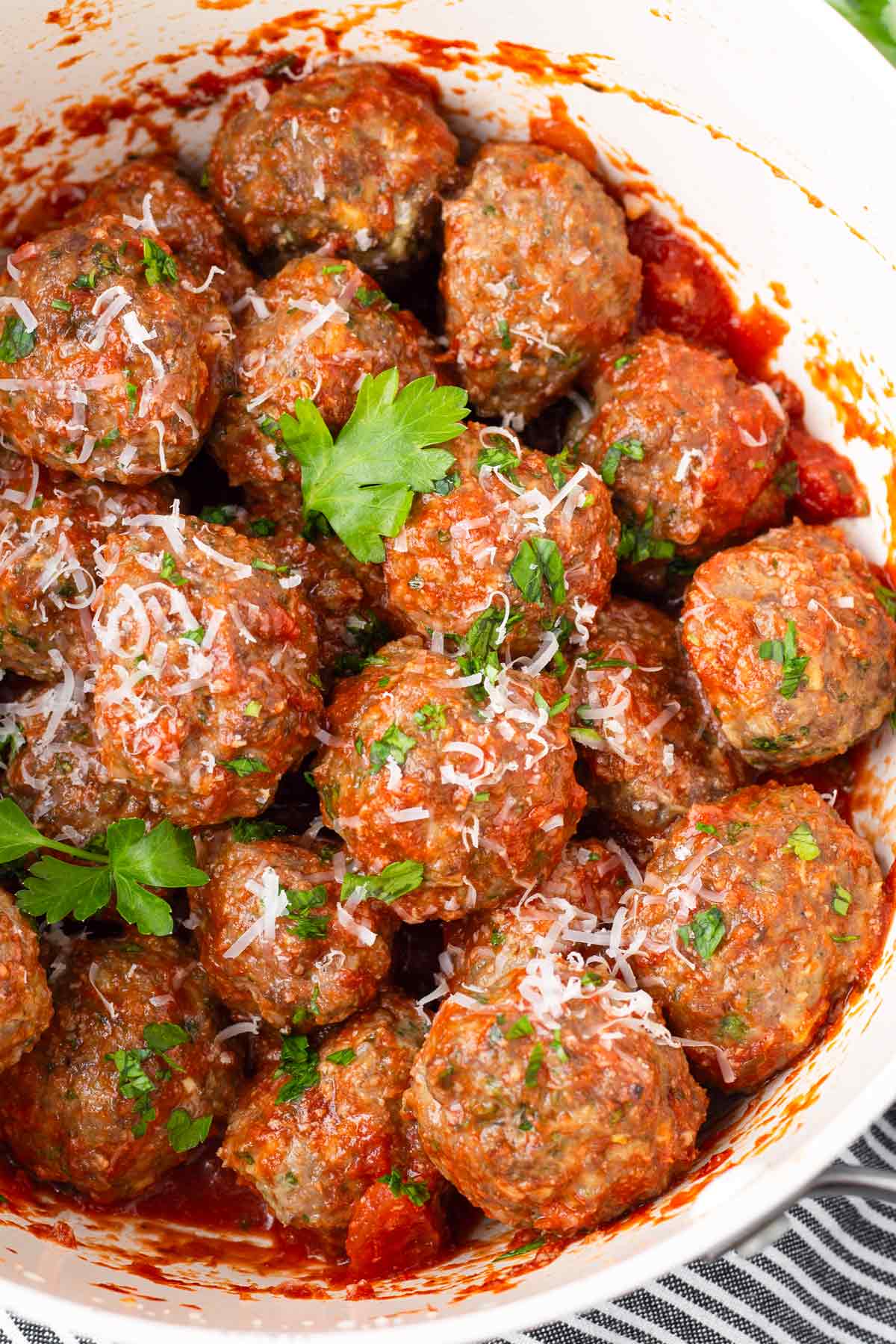 a pot with lots of garnished and sauced up meatballs