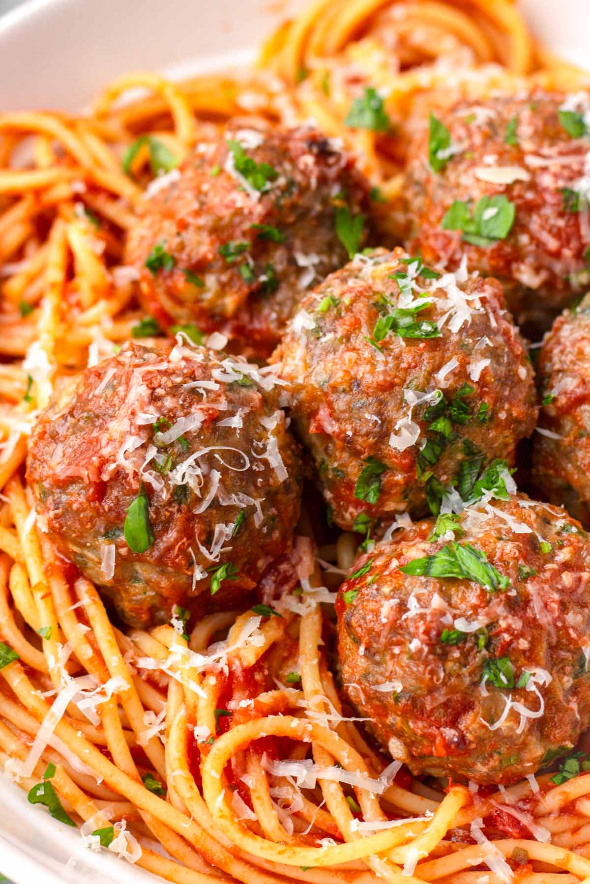 close-up of saucy italian meatballs with garnish