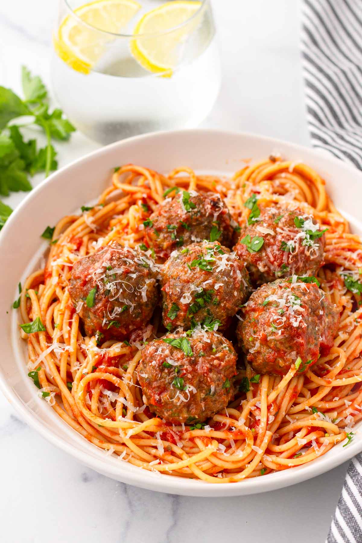 a bowl of italian meatballs on marinara and spaghetti
