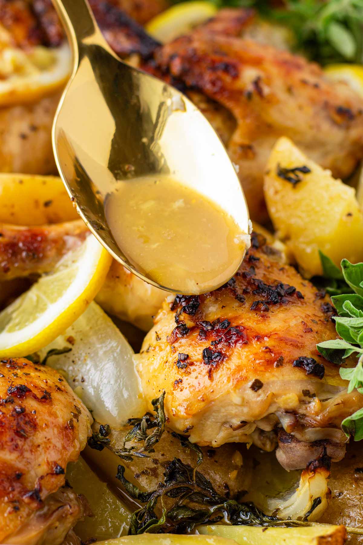 spooning pan juices over greek lemon chicken