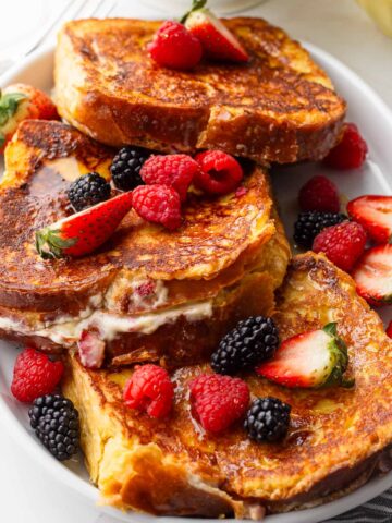 three stuffed french toasts with cream cheese and berries