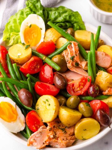 tossed salmon nicoise salad in plate
