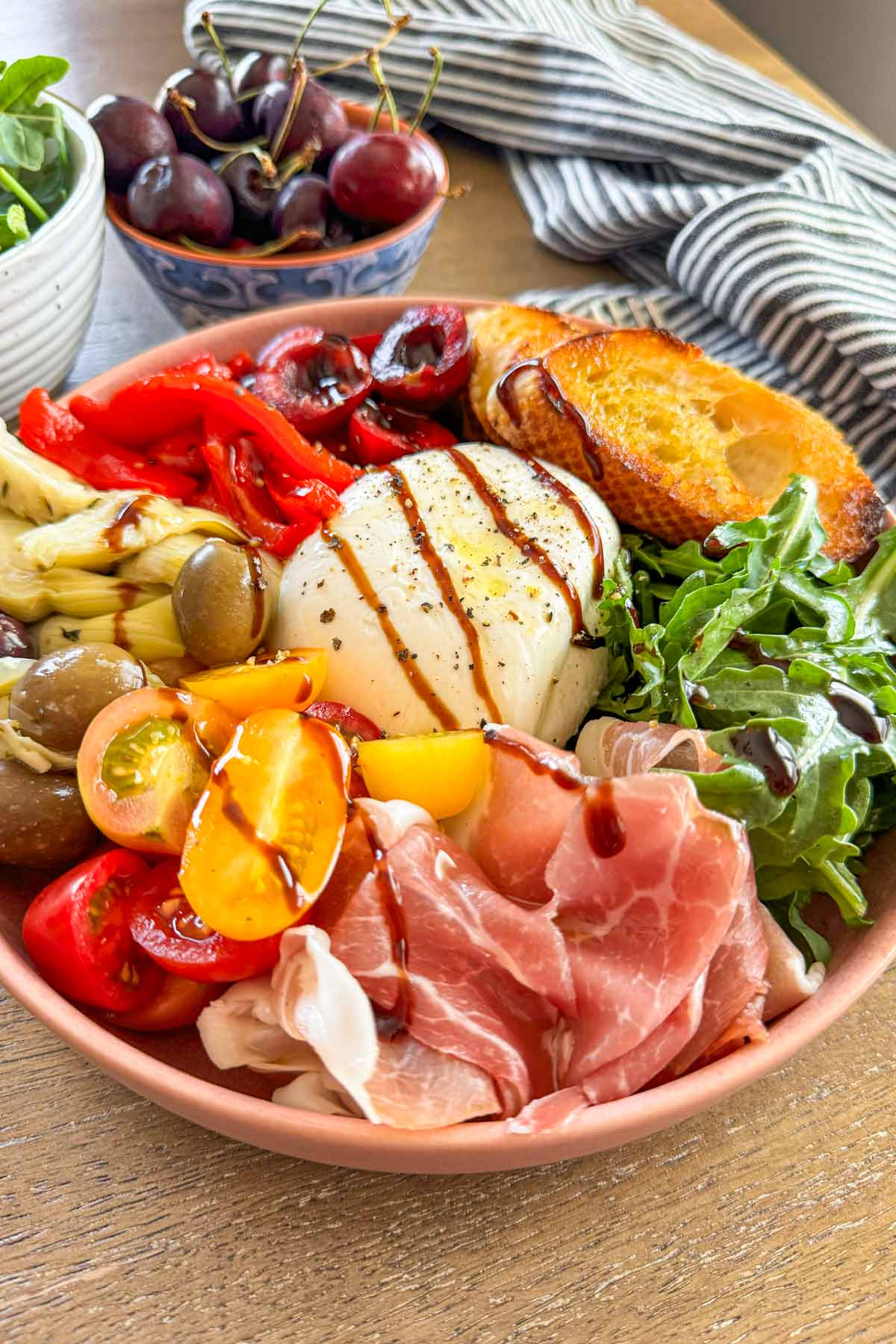 beautiful assembled bowl with burrata, greens and prosciutto