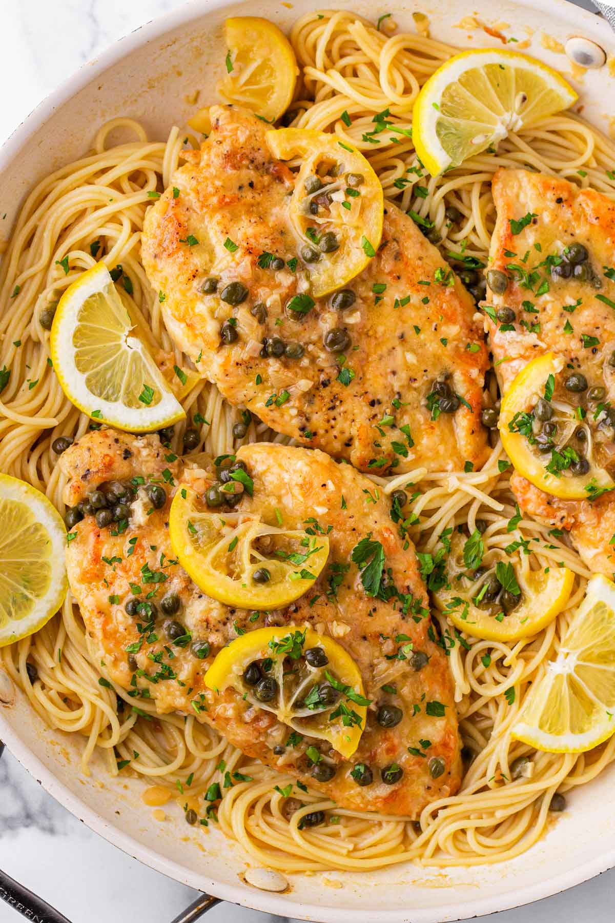 top view of skillet chicken piccata with spaghetti