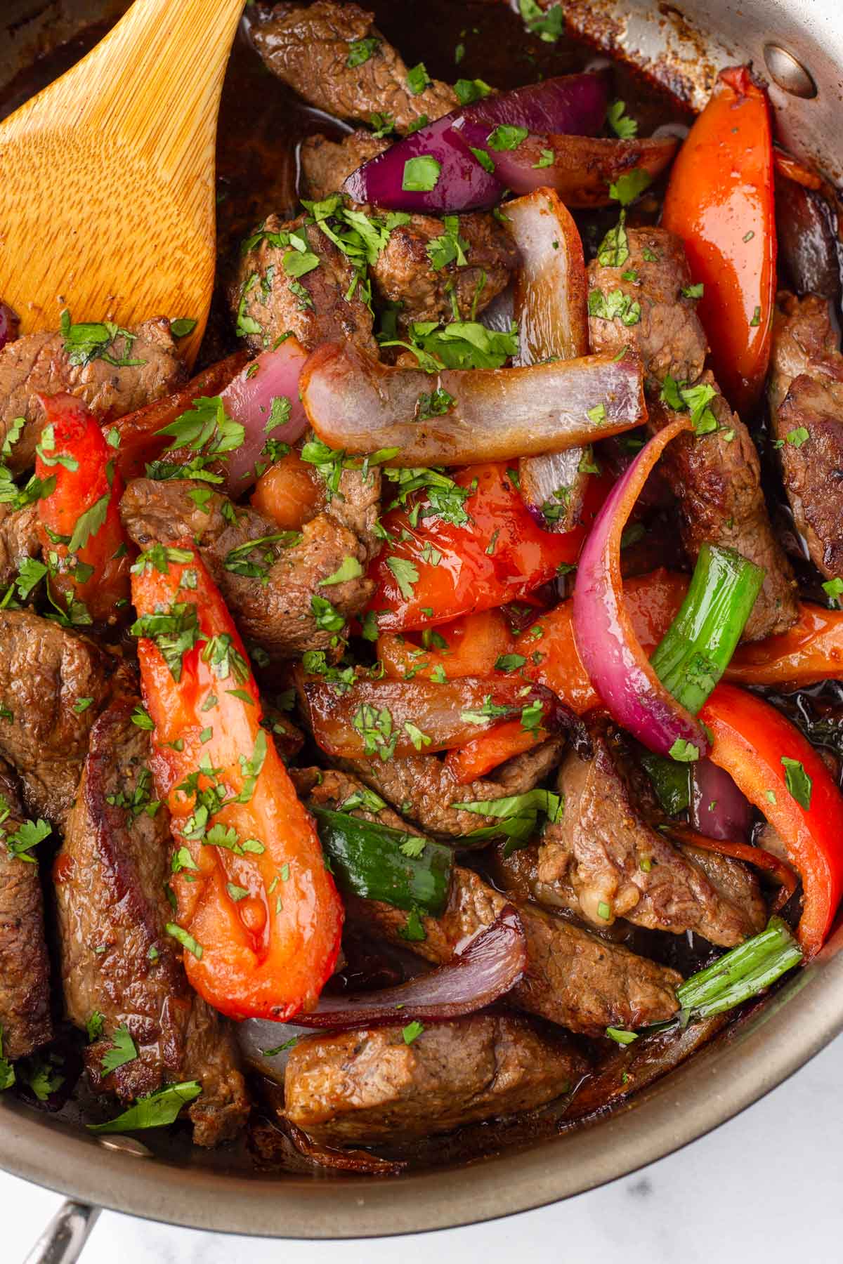 lomo saltado with garnish in skillet