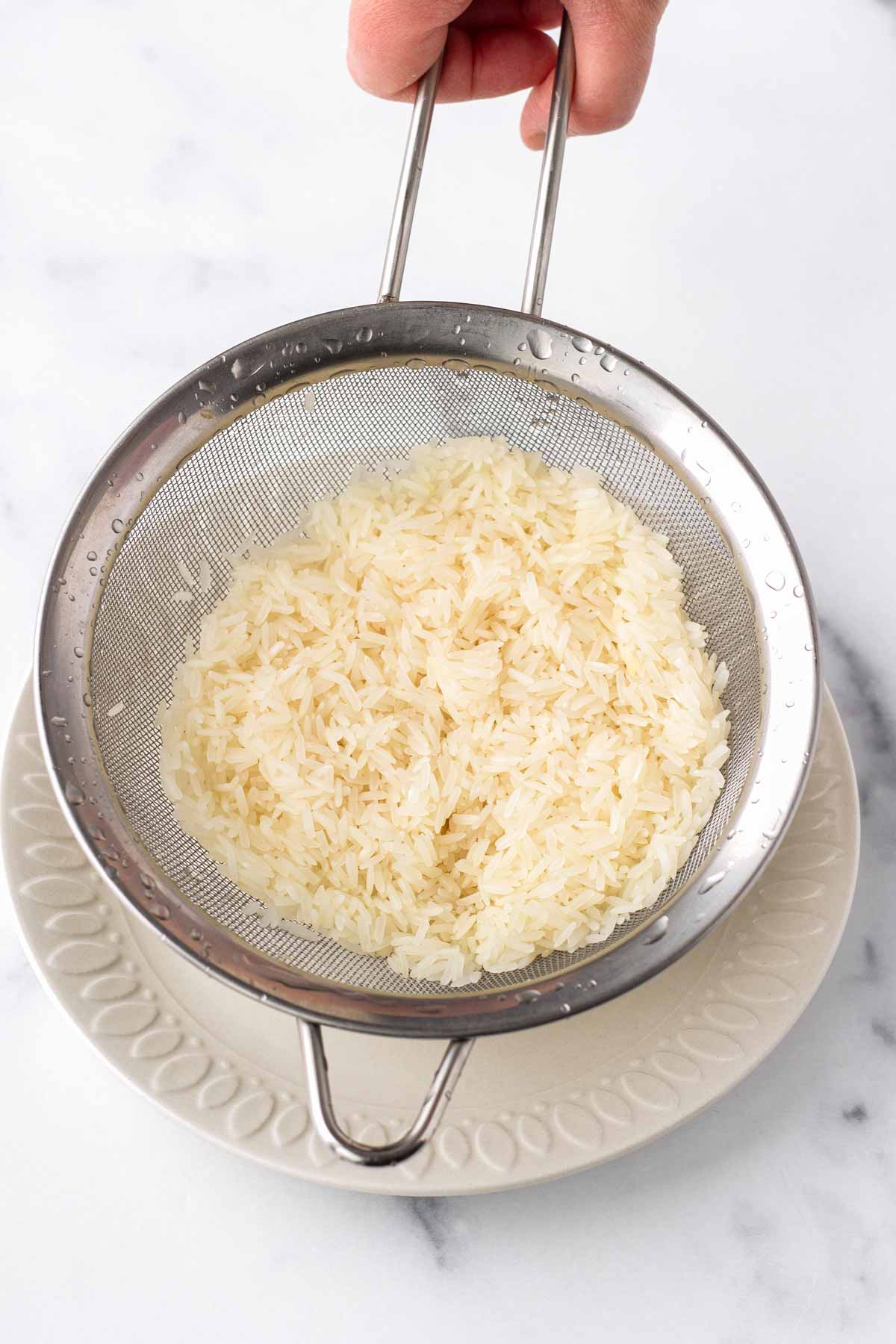 rinsing long grain rice over colander