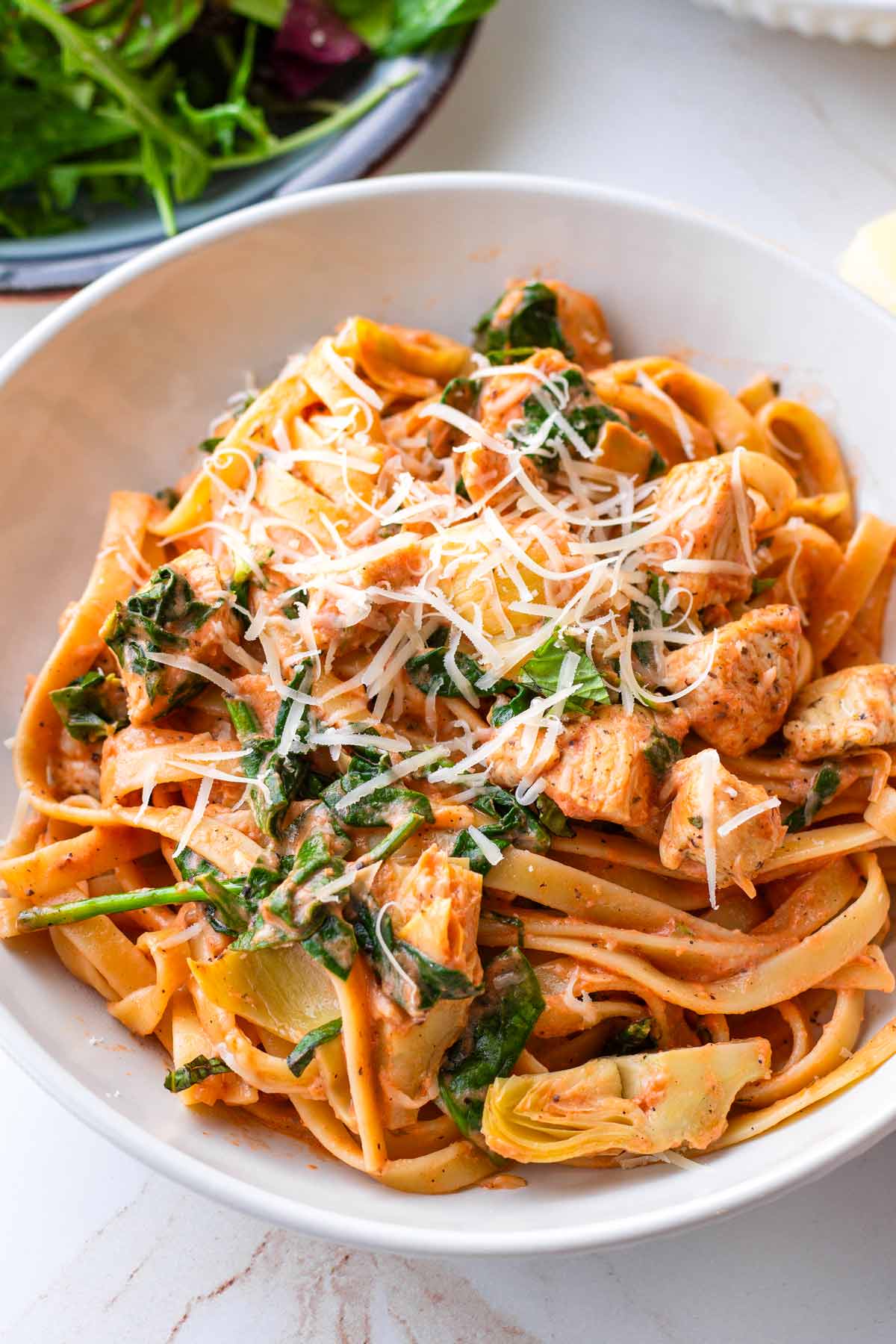 bowl of chicken pasta with spinach