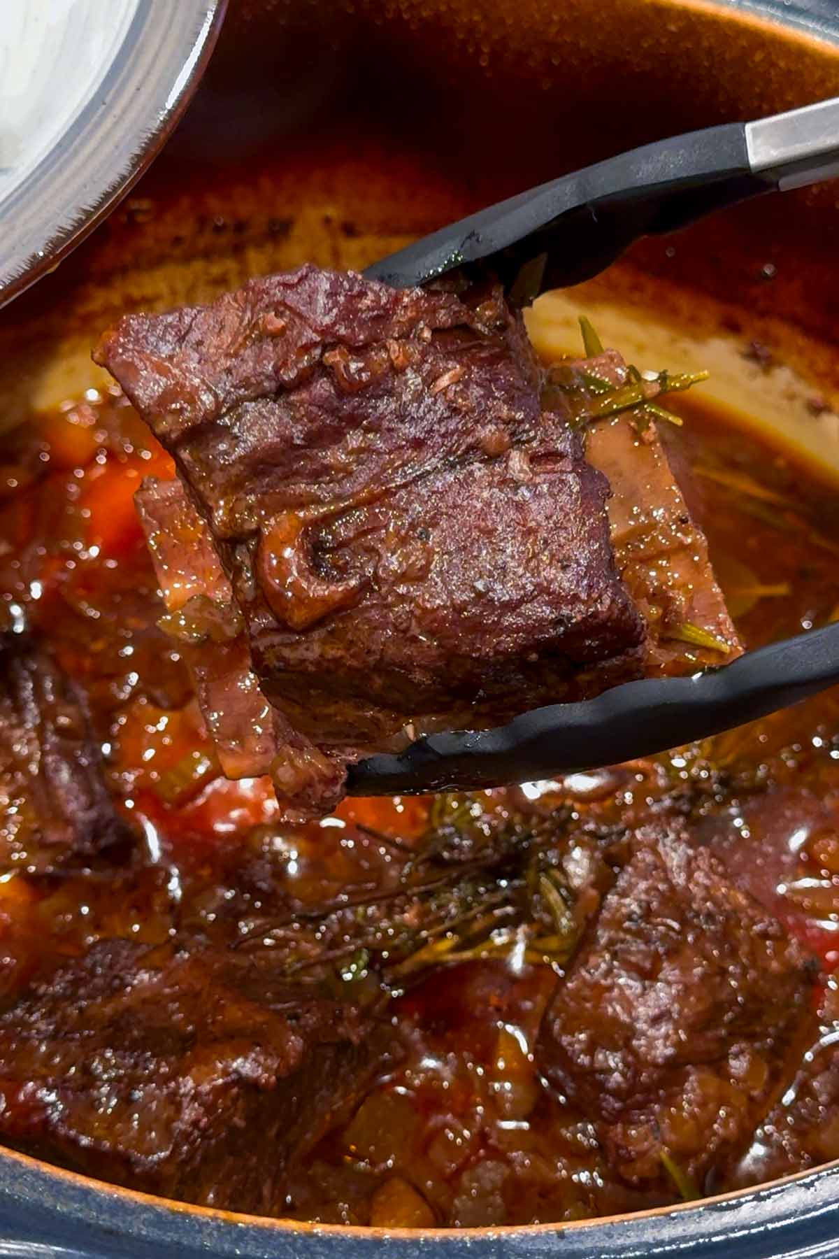 holding a piece of braised short rib