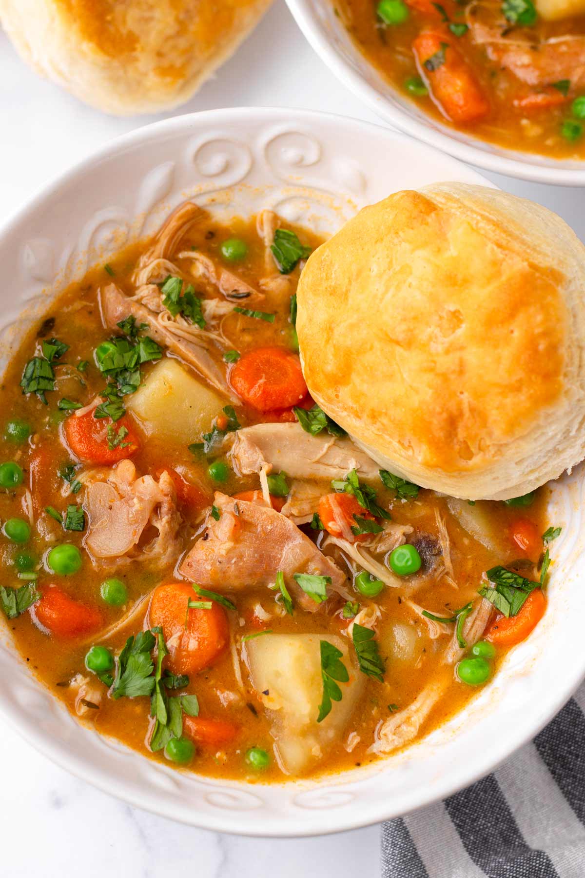 bowl of crockpot chicken stew with biscuit