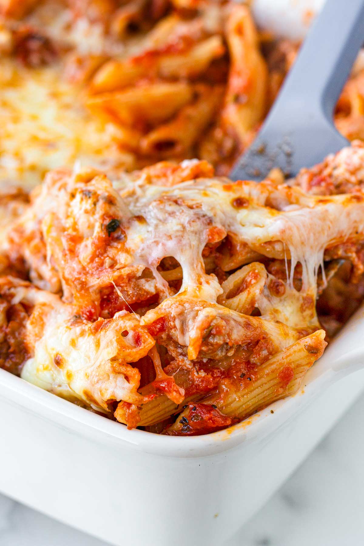 cheese pull of baked penne pasta with sausage