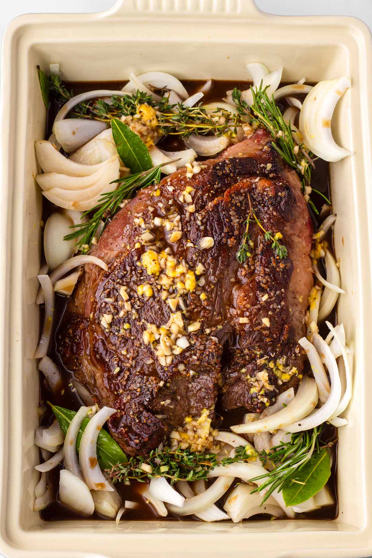 assembled chuck roast, onions, and liquid in a baking pan