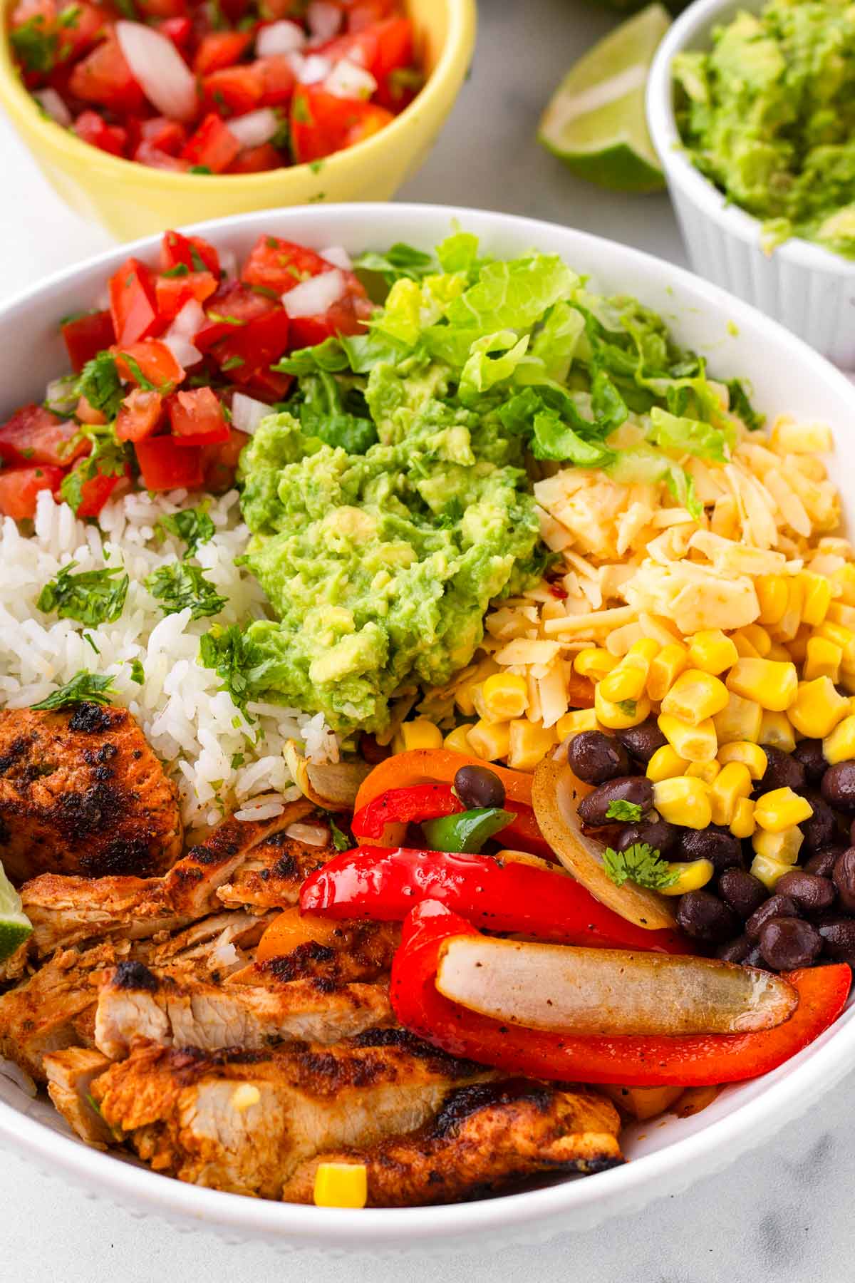 assembled chicken fajita bowls with guacamole and other toppings