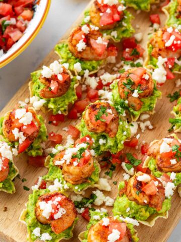 shrimp bites with guacamole on top of tortilla scoops