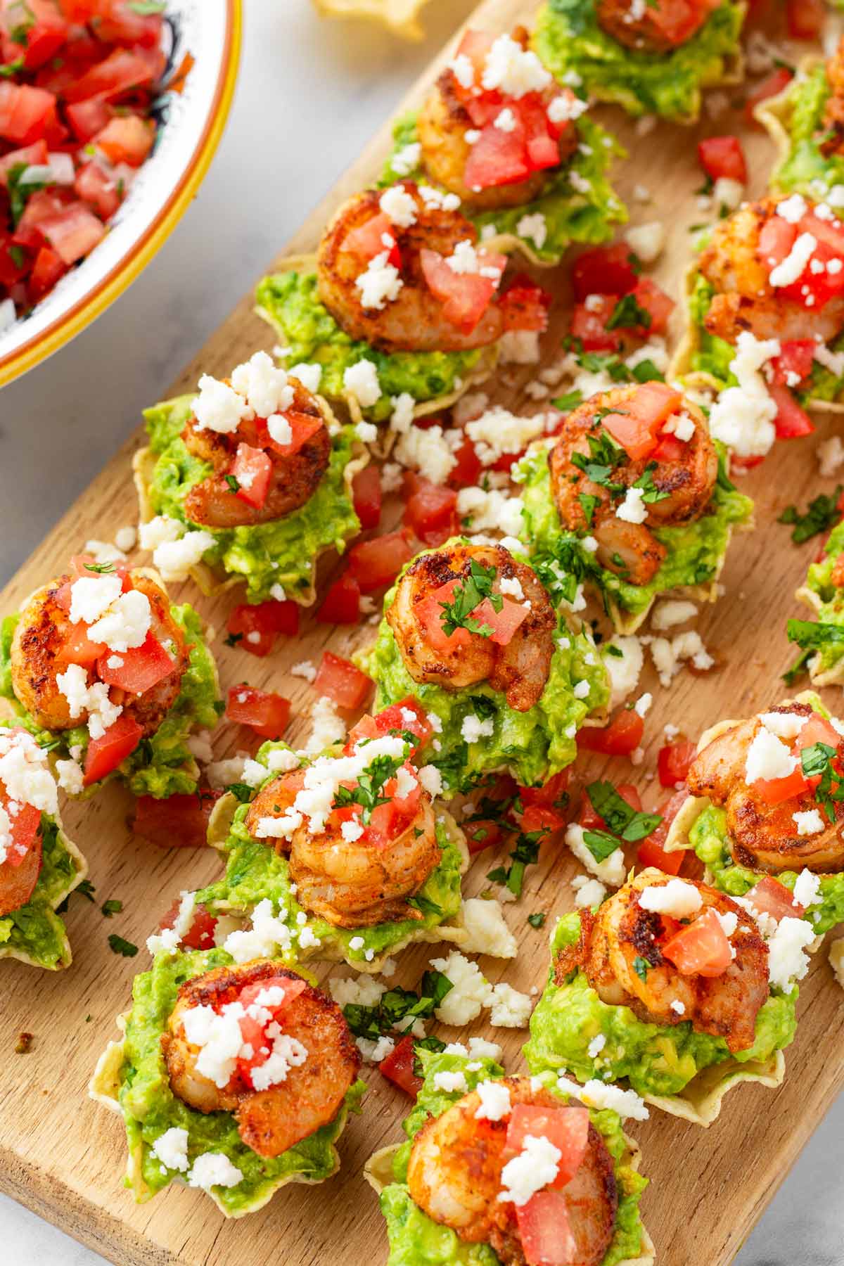 shrimp bites with guacamole on top of tortilla scoops