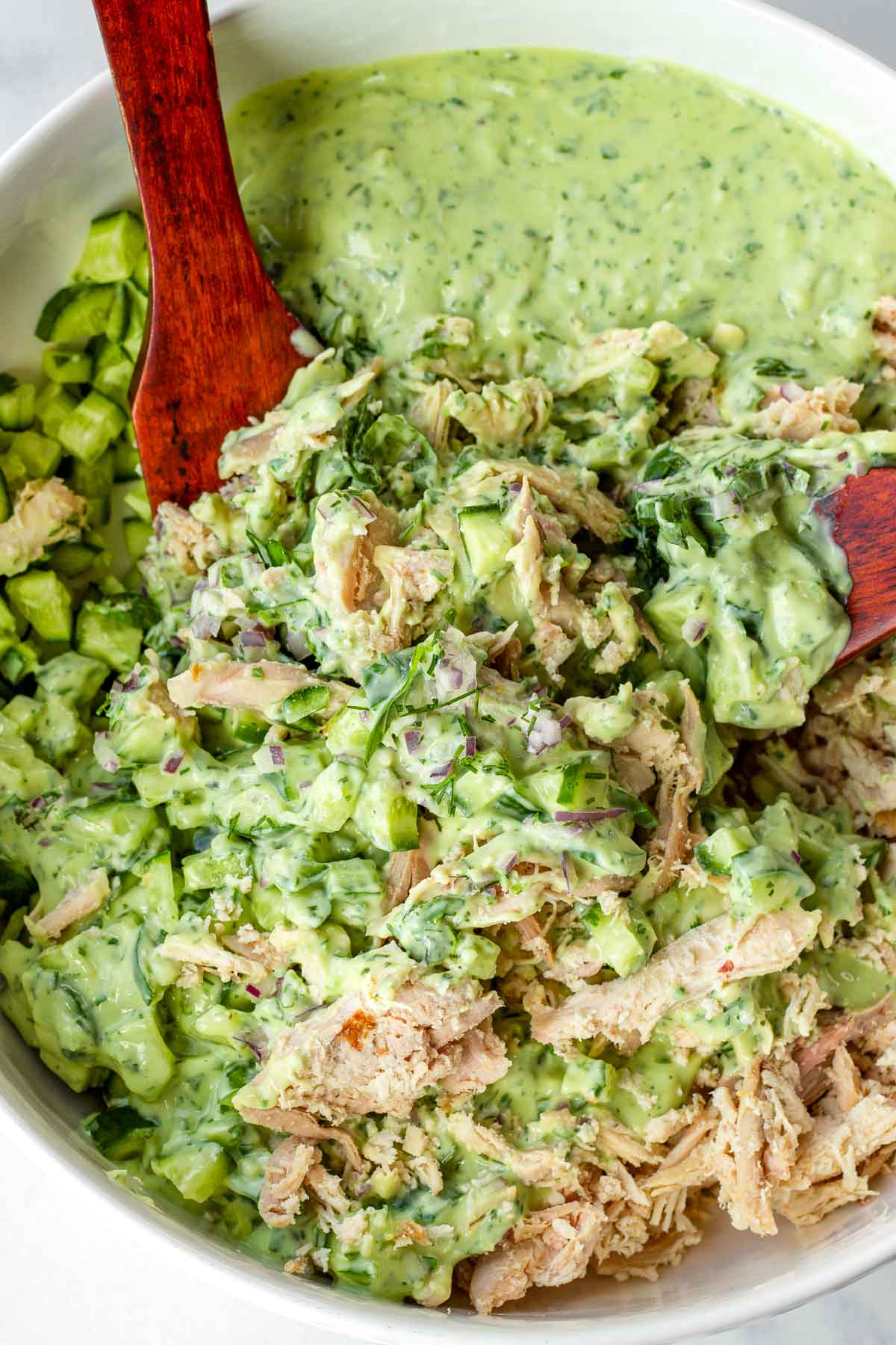mixing salad and dressing with spoons