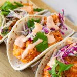 fried shrimp tacos topped with bang bang sauce and slaw