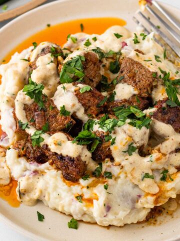creamy garlic steak bites over mashed potatoes