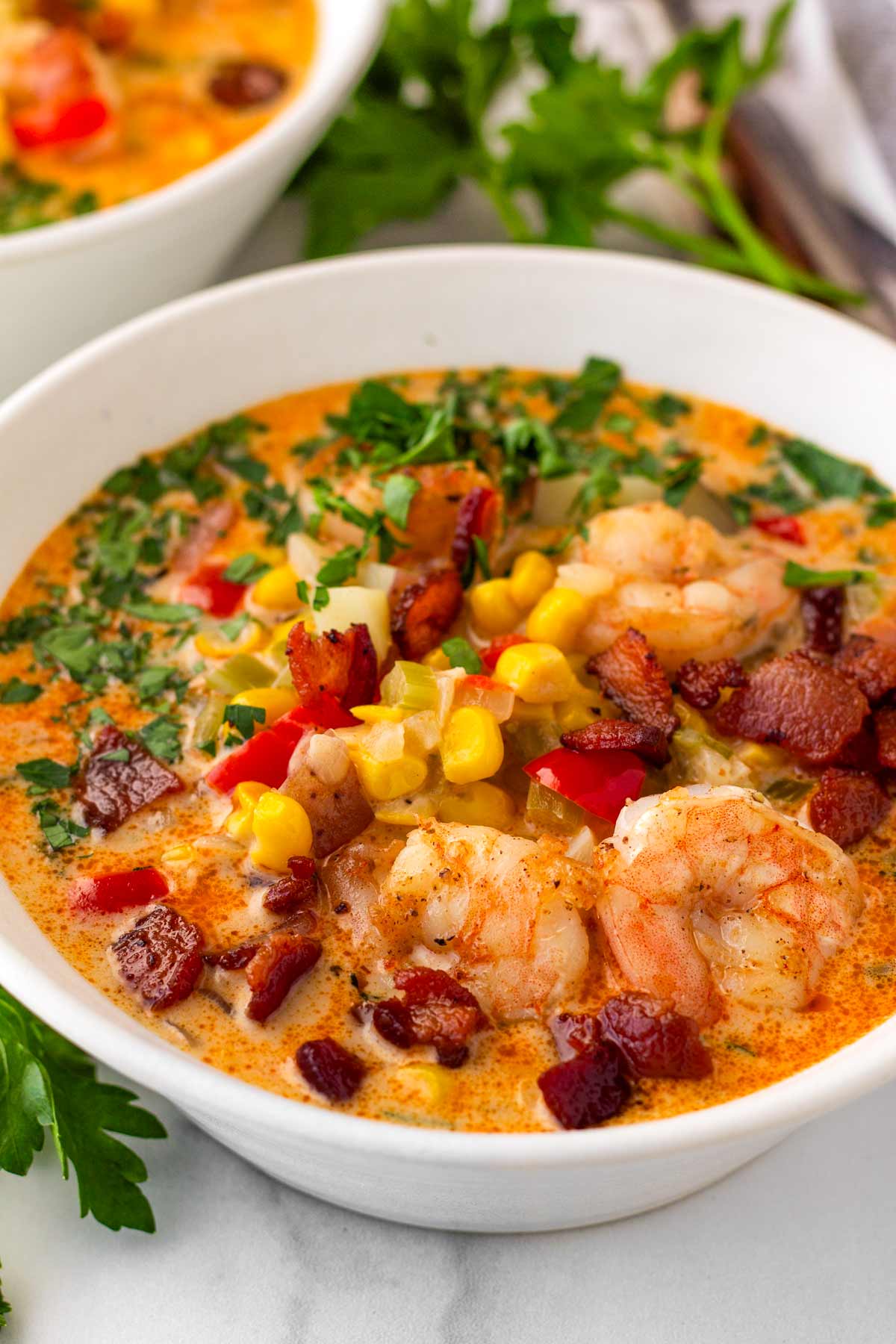 bowl of creamy shrimp corn chowder with lots of garnish