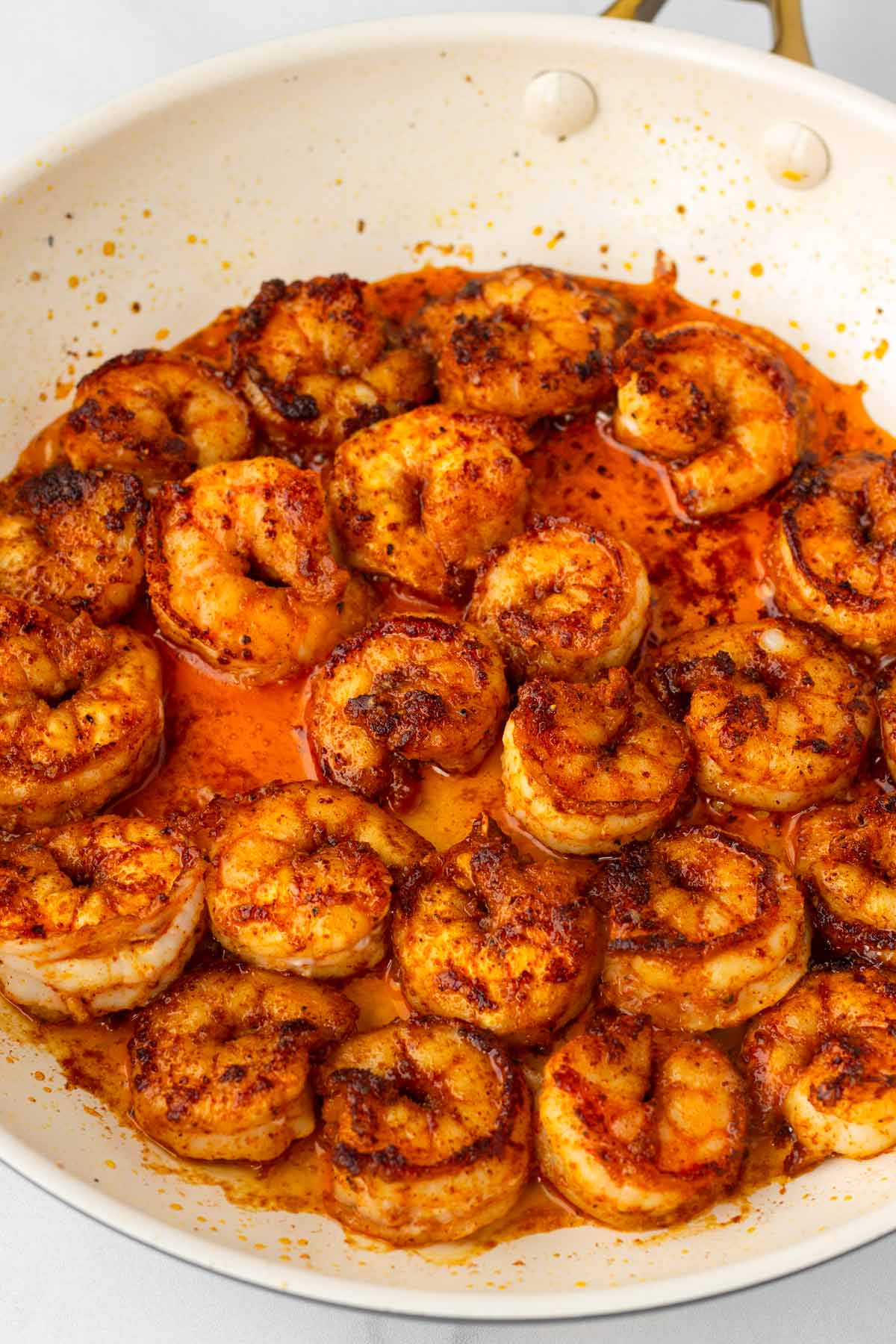 cooking the seasoned shrimp in a skillet