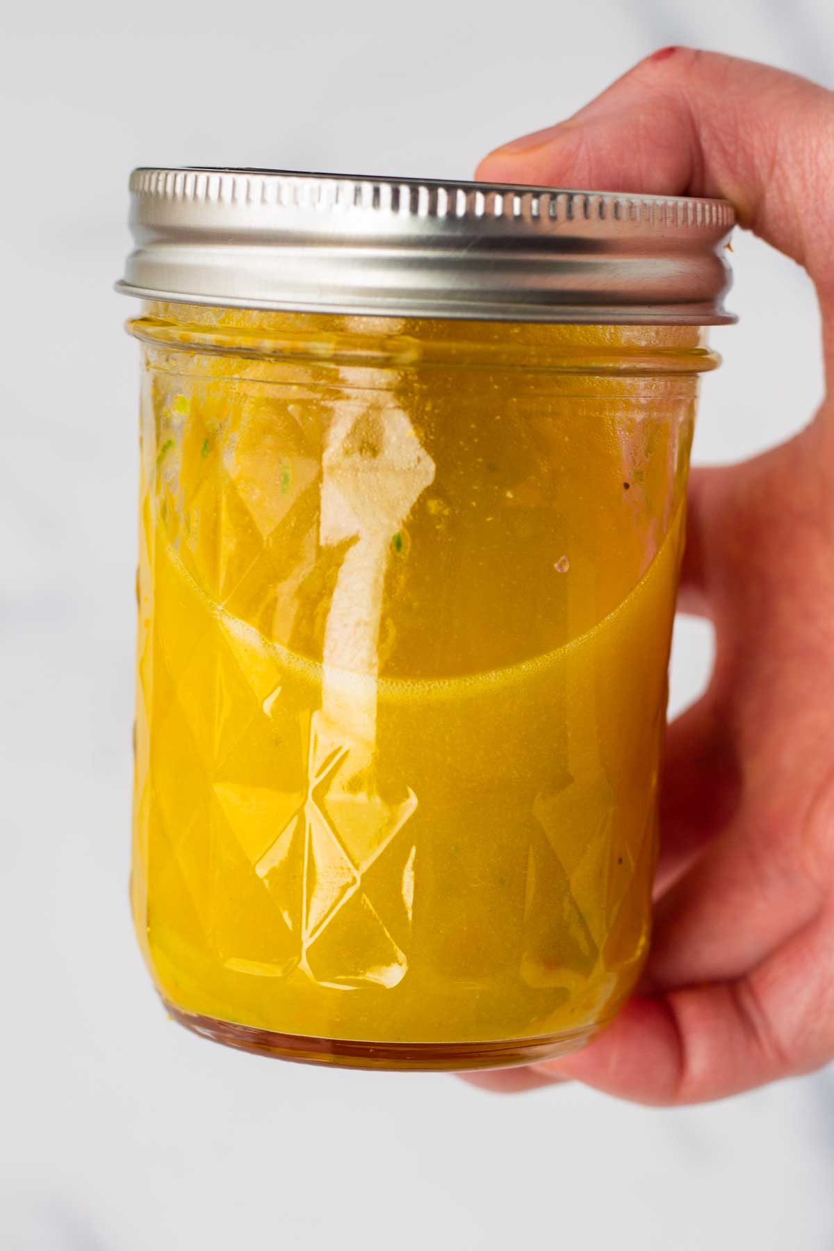 tossing the citrus salad in a mason jar