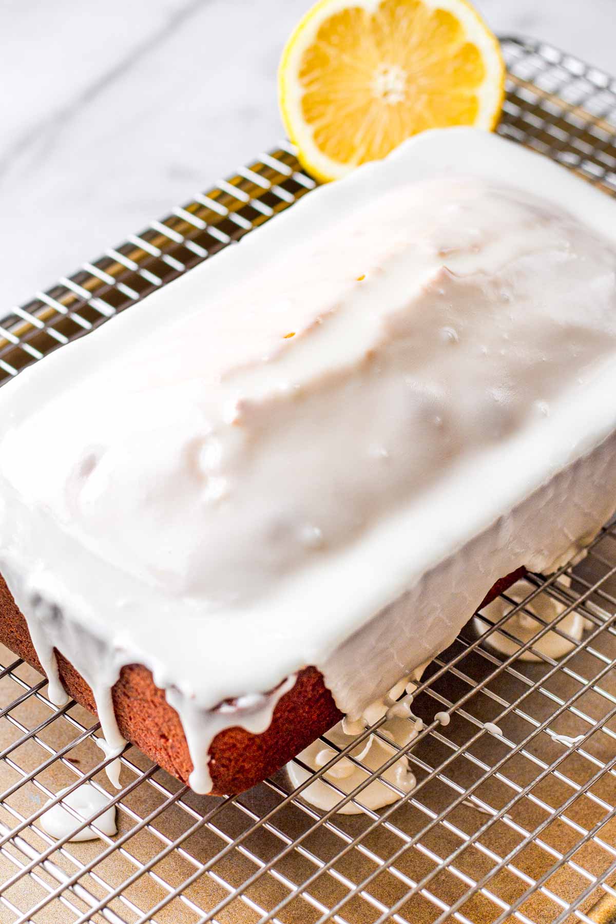glazed lemon loaf sitting on top of a wire rack